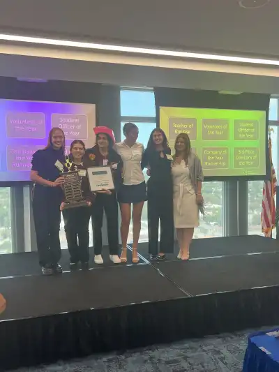 teenagers on stage with an award